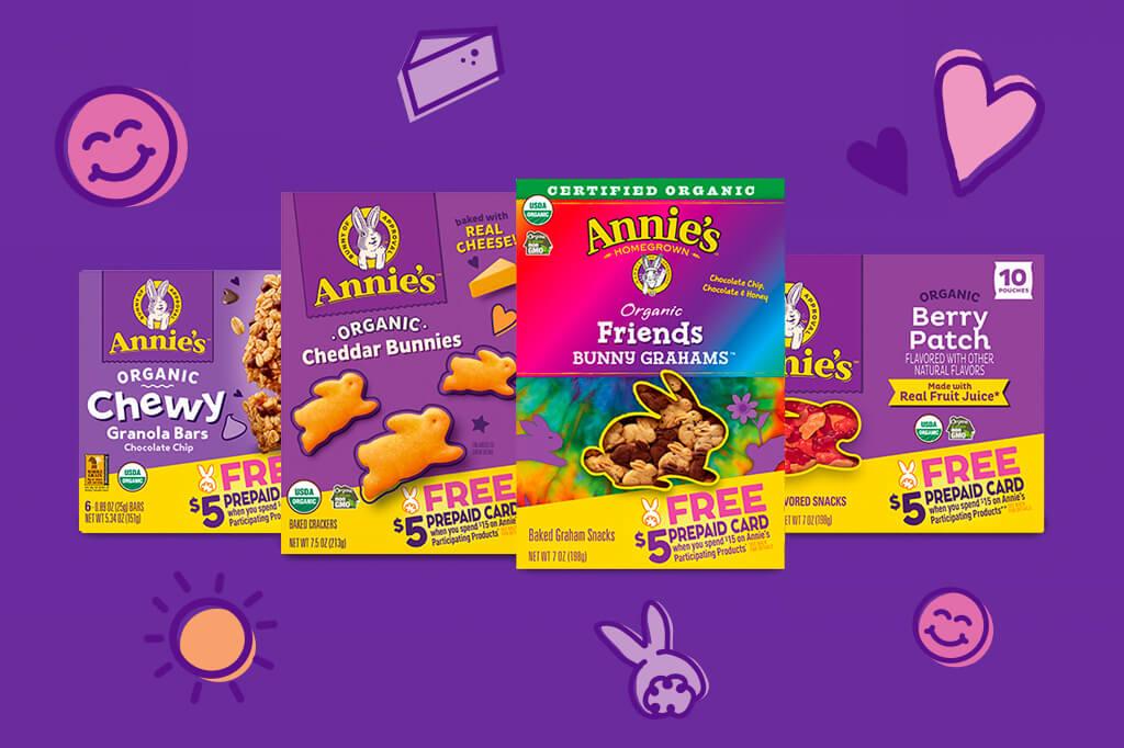 A purple background with a variety of front of packs of snacks on it such as Annie's Bunny Grahams, Annie's Cheddar Bunnies, Annie's Chewy Granola Bars and Annie's Fruit Snacks.