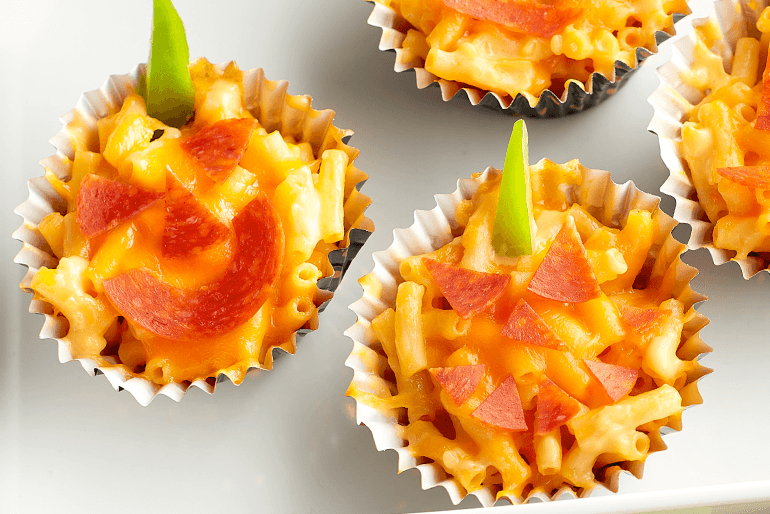 An assortment of Mac and Cheese Jack-o'-lantern cups on a surface.