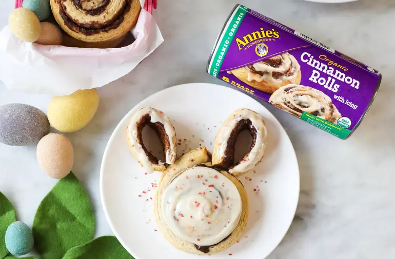 Annie's cinnamon rolls shaped to look like a bunny's head next to them is a tube of the cinnamon rolls