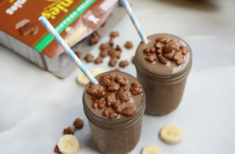 Two chocolate milkshakes with Annie's chocolate bunny cereal in the background
