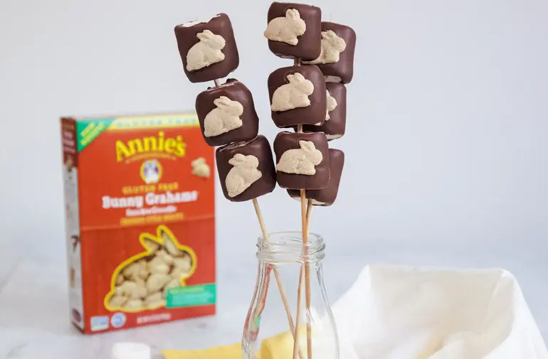 3 Gluten Free S'Mores Bunny Pops sitting in a recycled glass milk jar with a box of Annie's Bunny Grahams in the background.