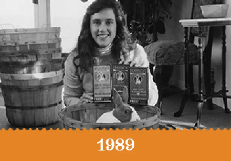 Year 1989 - A black and white photo of Annie Withey with Bernie and 3 boxes of Mac and Cheese