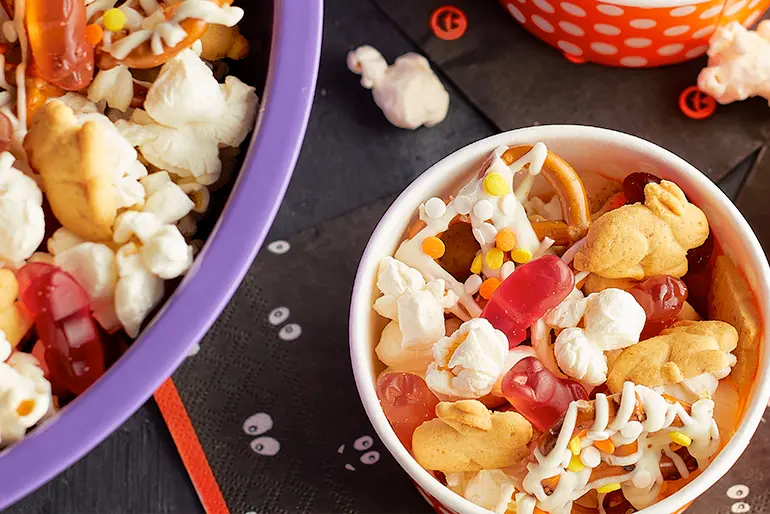 A halloween Cobweb Crunch Mix served in a bowl on thematically appropriate napkins.