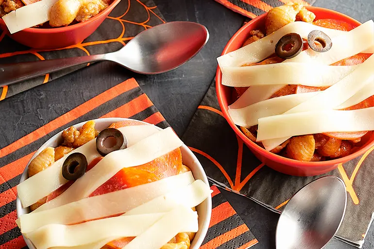 Mummy Pizza Pasta Bowls served with spoons and resting on Halloween napkins.