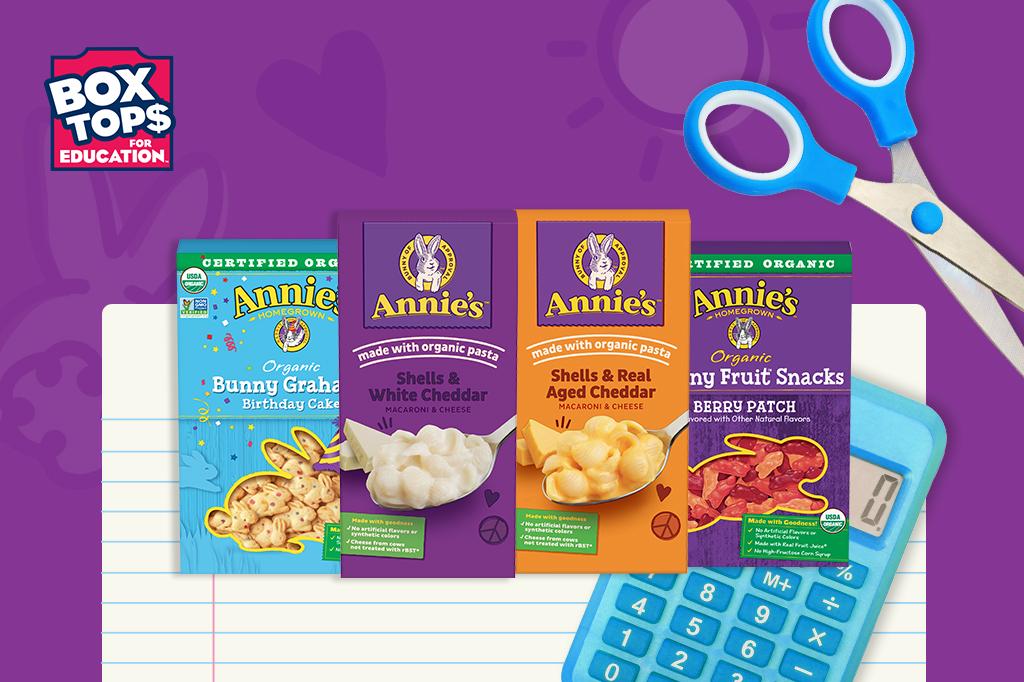 Collage image of four packages of different Annie's products on a purple background with a Box Tops For Education logo, notebook paper, a calculator and a scissors.