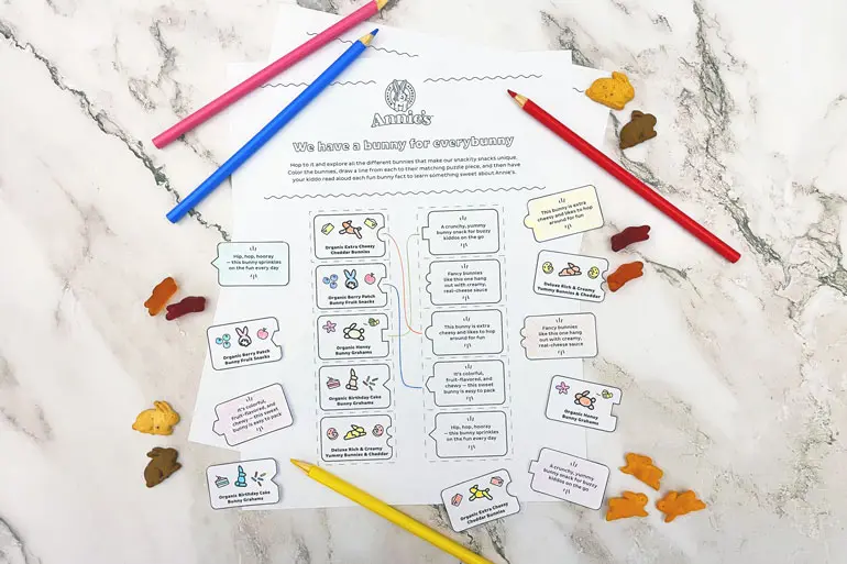 Annie's Activity worksheet "A bunny for everybunny" on a marble table with single Bunny Grahams, fruit snacks and colored pencils.