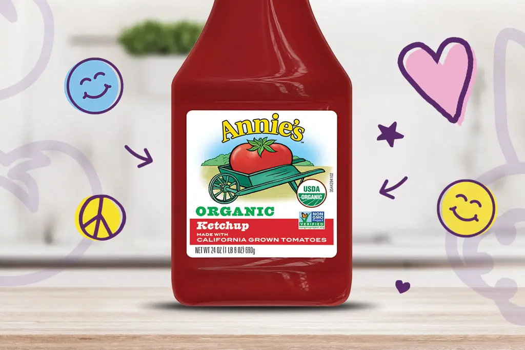 A bottle of Annie's Organic Ketchup sitting on a kitchen counter.
