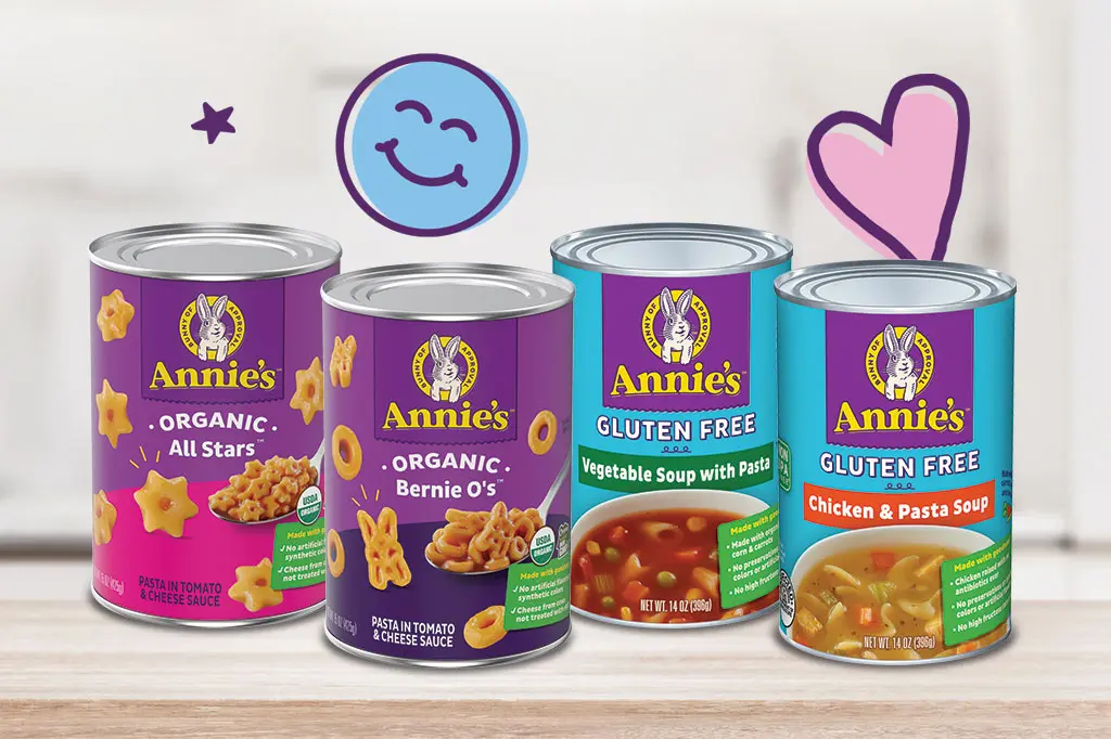 Single cans of Annie's Organic and Annie's Gluten Free soup varieties sitting on a kitchen counter.