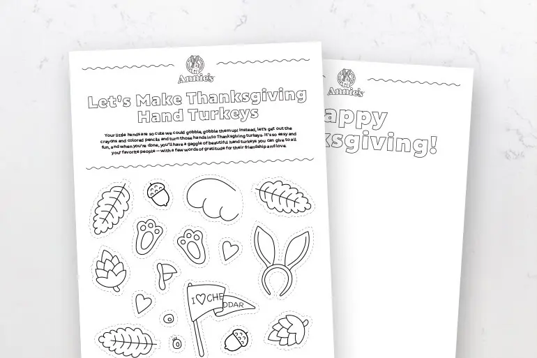 A black and white Annie's Activity sheet coloring page titled "Fun with Thanksgiving Hand Turkeys" laying flat on a marble slab.