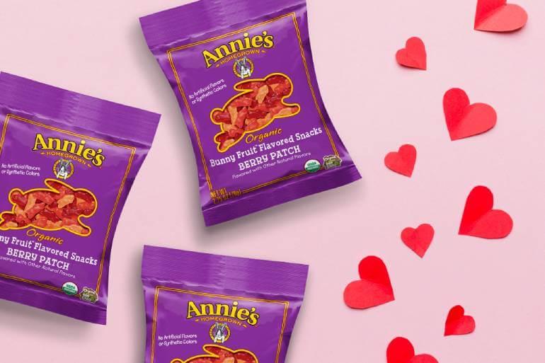 Three bags of Annies' Bunny Fruit Flavored Snacks Berry Patch surrounded by little paper hearts