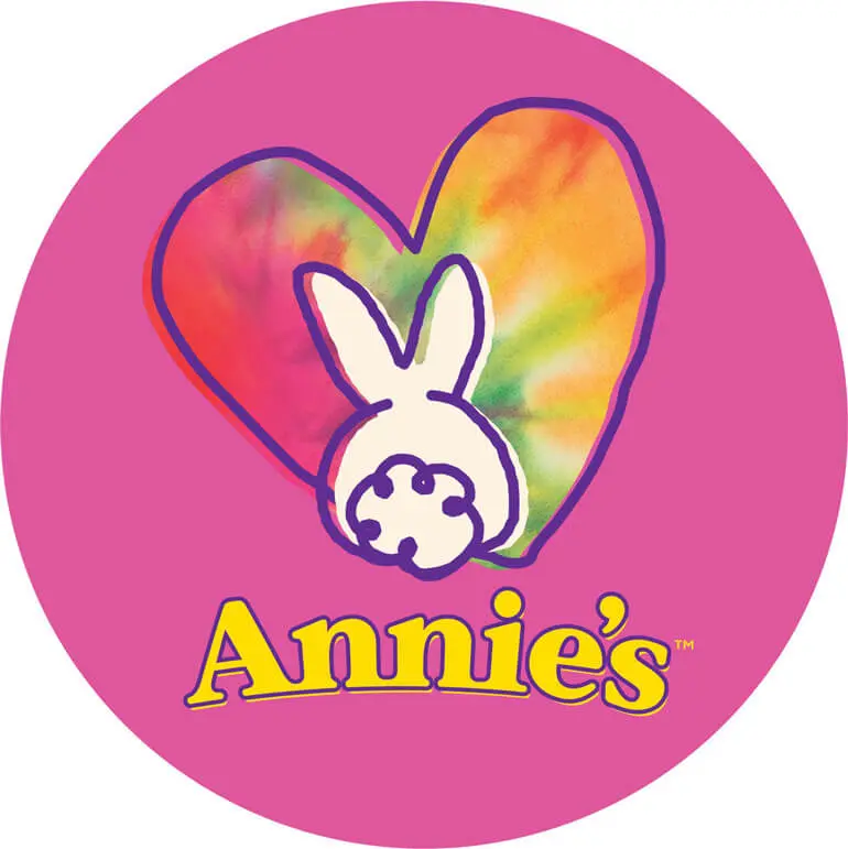 Round pink sticker with a bunny in front of a heart and the Annie's logo.